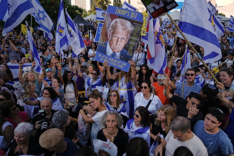 People react as they gather to watch a live broadcast of Israeli hostages released from Gaza at a plaza known as hostages square in Tel Aviv, Israel, Monday, Oct. 13, 2025. The release took place as part of a cease-fire agreement between Israel and Hamas.