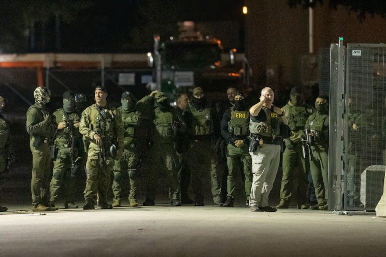 Federal law enforcement officers stand guard in the open gate of the fence built on Beach Street outside the Broadview ICE processing facility in suburban Broadview, Tuesday, Oct. 14, 2025. (Tyler Pasciak LaRiviere/Chicago Sun-Times via AP)