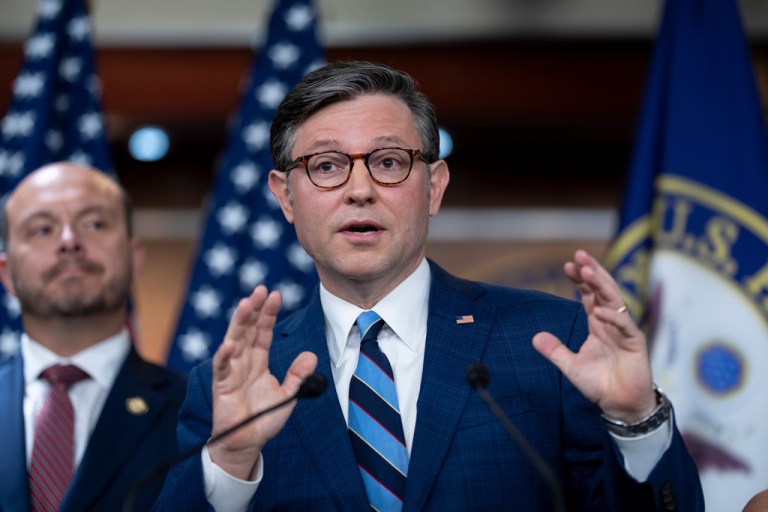 House Speaker Mike Johnson (R-LA), joined at left by Rep. Andrew Garbarino (R-NY), gestures as he answers questions during a press conference.