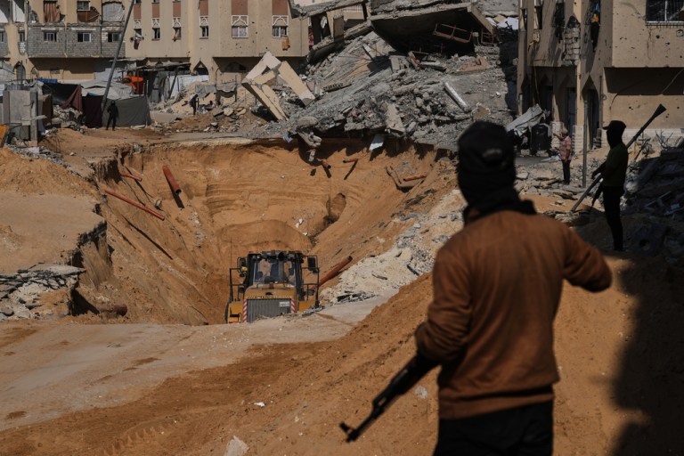 Members of the Hamas militant group search underground for the bodies of Israeli hostages amid destroyed buildings in Khan Younis, in the southern Gaza Strip, Sunday, Oct. 19, 2025.