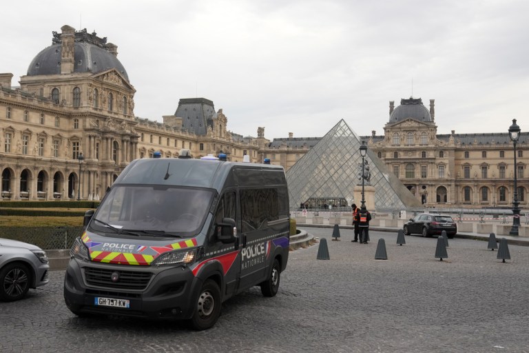 A police car patrols in the courtyard of the closed Louvre museum after a robbery Sunday, Oct. 19, 2025 in Paris. (AP Photo/Thibault Camus)