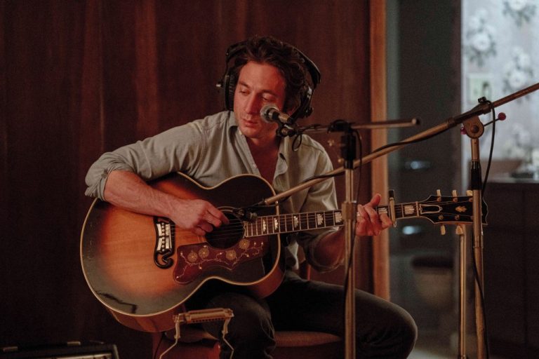 Jeremy Allen White acts as Bruce Springsteen while playing a guitar in a scene from 
