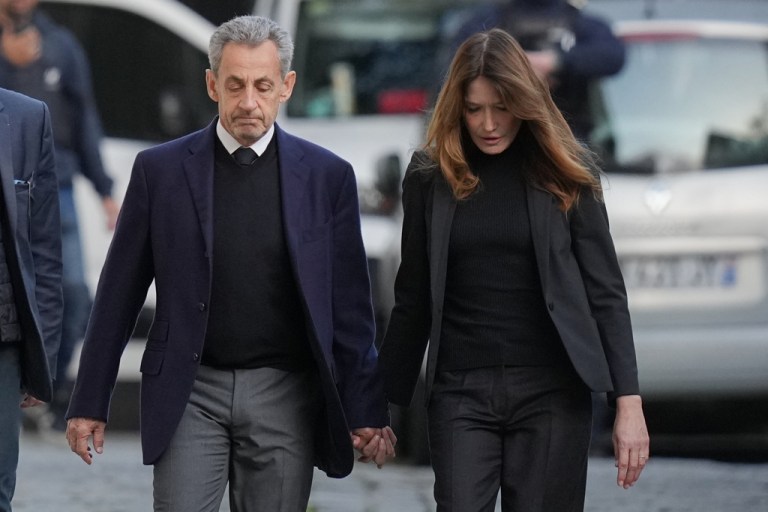 Former French President Nicolas Sarkozy and his wife Carla Bruni-Sarkozy leave their home Tuesday, Oct. 21, 2025 in Paris as Nicolas Sarkozy heads to prison to serve time for a criminal conspiracy to finance his 2007 election campaign with funds from Libya. (AP Photo/Thibault Camus)