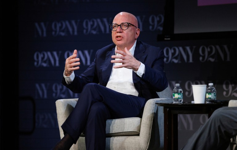 Michael Wolff sits in a chair on a stage