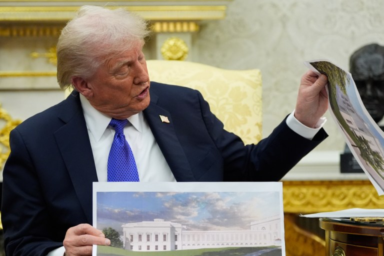 President Donald Trump holds artist renderings of the new White House ballroom