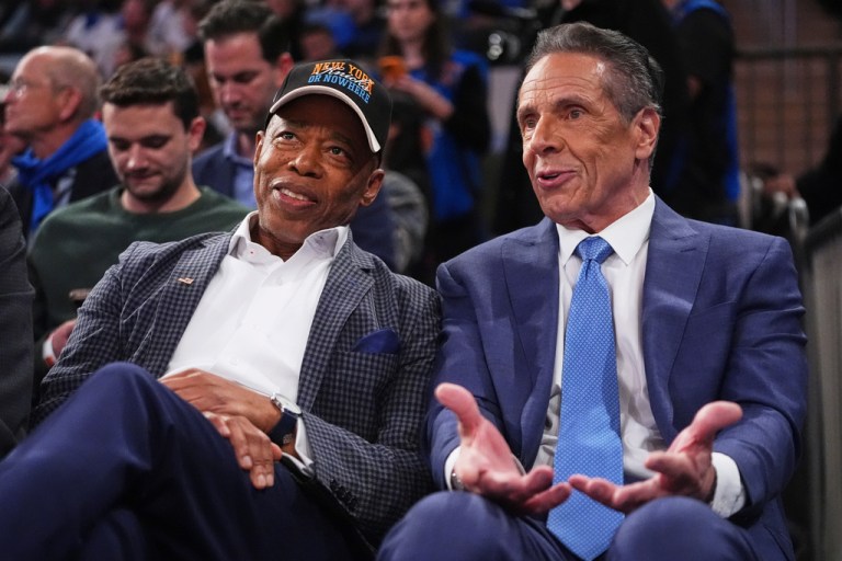 New York City Mayor Eric Adams and former New York Gov. Andrew Cuomo speak while sitting next to each other.
