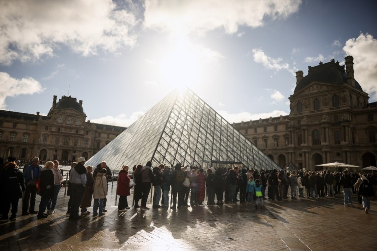 Visitors queue outside the Louvre museum