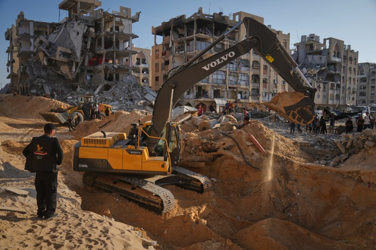 Palestinians watch machinery and some workers from Egypt searching for the bodies of hostages at Hamad City, in Khan Younis, southern Gaza Strip, Sunday, Oct. 26, 2025.