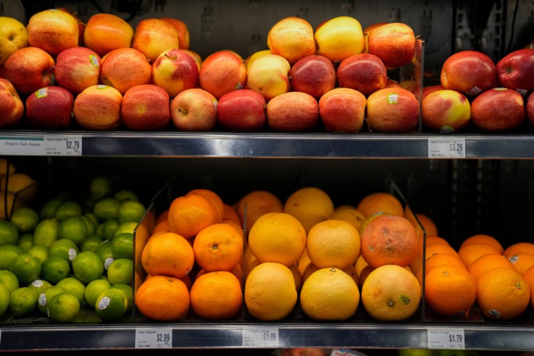 Produce is displayed on shelves in a market.