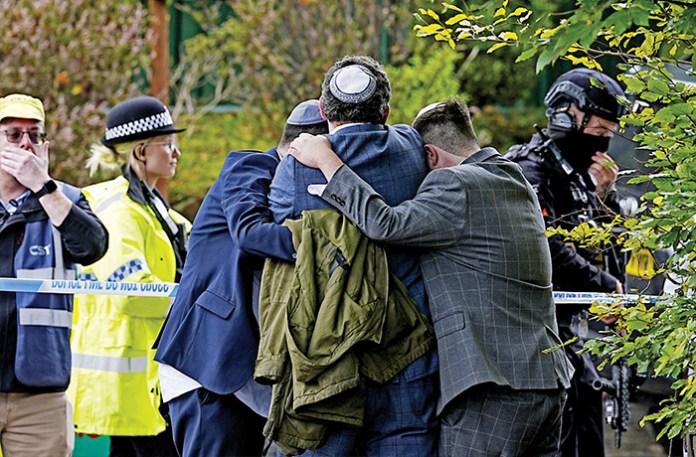 Synagogue members comfort each other after the Manchester attack, Oct. 2, 2025. (Peter Byrne / PA Images / Getty Images)