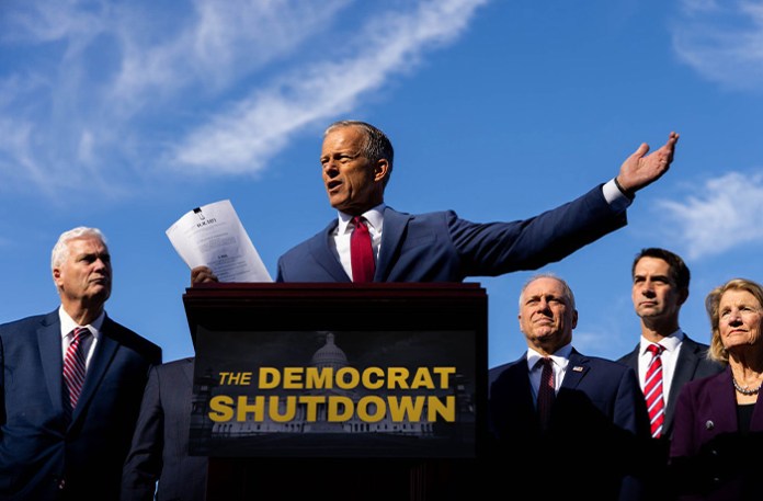 Senate Majority Leader John Thune (R-SD) holds a copy of the continuing appropriations bill at a GOP Leadership press conference on the government shutdown at the Capitol on Oct. 1. (Graeme Jennings/Washington Examiner)