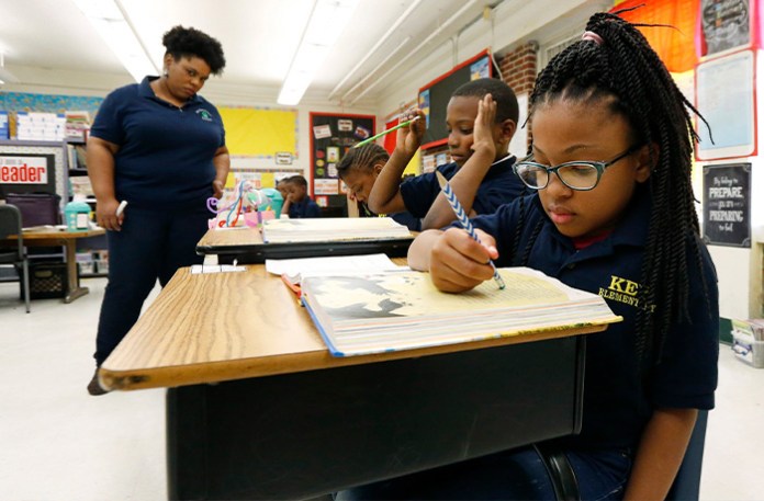 In this 2019 photo, Elize’a Scott, a Key Elementary School third grade student (right) reads under the watchful eyes of teacher Crystal McKinnis, left, in Jackson, Miss. About one in four Mississippi third graders failed a toughened reading test on the first try this spring, according to results released Wednesday, May 22, 2019, by the Mississippi Department of Education, leaving it unclear if the students will advance to fourth grade. (Rogelio V. Solis/AP)