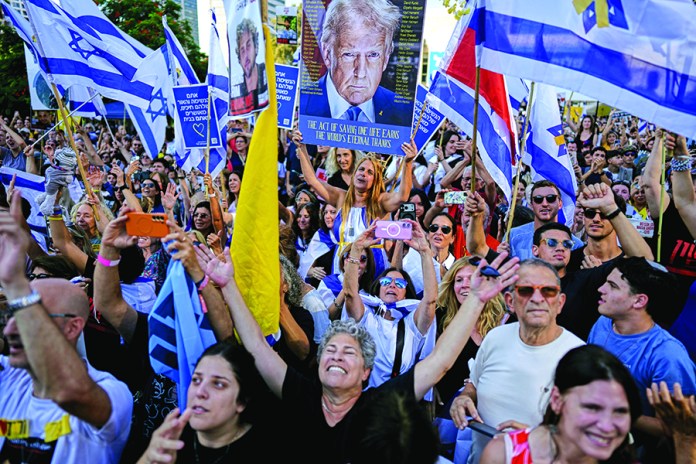 People react as they gather to watch a live broadcast of Israeli hostages released from Gaza at a plaza known as hostages square in Tel Aviv, Israel, Monday, Oct. 13, 2025. The release took place as part of a cease-fire agreement between Israel and Hamas. (AP Photo/Oded Balilty)