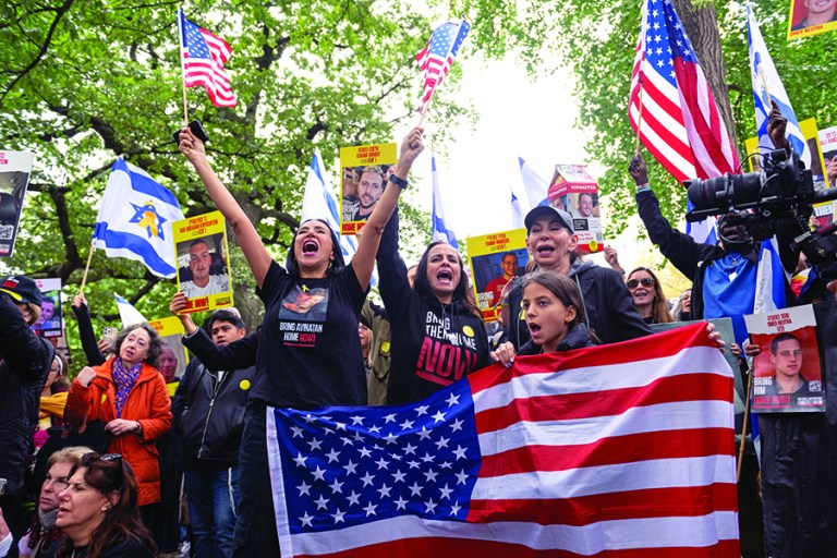 People hold US and Israeli flags during a 