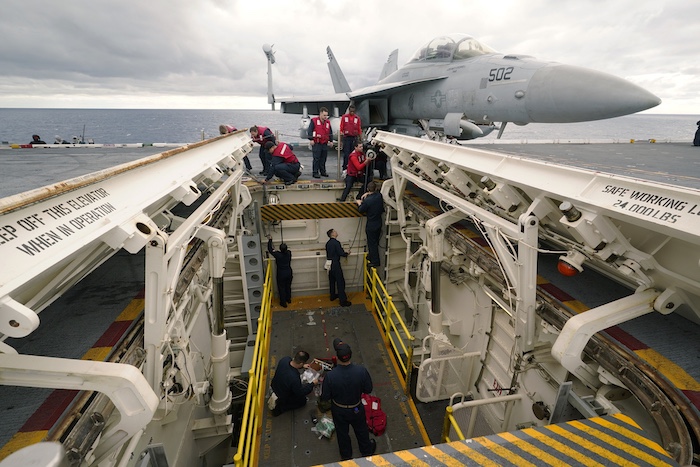 Weapons personnel work on a weapons elevator on the flight deck of the aircraft carrier USS Gerald R. Ford.