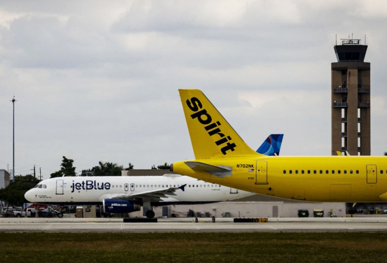 Spirit and JetBlue planes at Fort Lauderdale-Hollywood International Airport (FLL) in Fort Lauderdale, Florida, US, on Wednesday, Nov. 1, 2023. The US crackdown on airline consolidation faces a new test this week with the trial of a government lawsuit claiming the $3.8 billion takeover of Spirit Airlines Inc. by JetBlue Airways Corp. would reduce competition and boost fares for passengers. Photographer: Eva Marie Uzcategui/Bloomberg via Getty Images