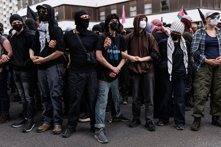People associated with the 'anti fascist' movement form a line outside the Barbican Thistle Hotel as anti-immigration, 'stand up to racism' and 'anti-fascist' groups all gather outside on August 2, 2025 in London, England. Protests outside hotels housing asylum seekers have increased in recent weeks, organised by far-right protest groups such as the Democratic Football Lads Alliance (DFLA). Stand Up To Racism (SUTR) holding counter-protests defending refugees have taken place at many of the sites, with more protests expected over the summer. (Photo by Dan Kitwood/Getty Images)