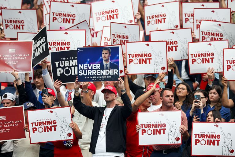 Attendees hold up signs at the memorial service for political activist Charlie Kirk at State Farm Stadium on September 21, 2025 in Glendale, Arizona. Kirk, the CEO and co-founder of Turning Point USA, was shot and killed on September 10th while speaking at an event during his 