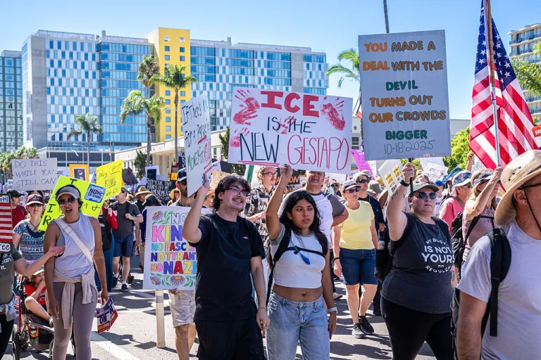 Protesters march through downtown San Diego holding placards critical of ICE and authoritarianism during the demonstration. Protesters gathered in downtown San Diego, California, to take part in the nationwide 