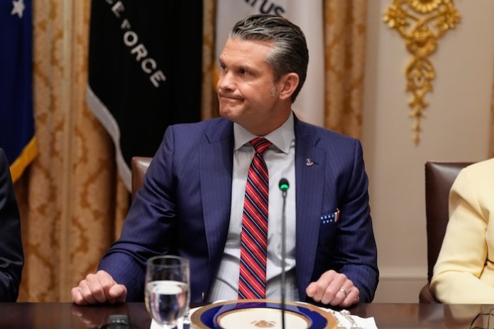 Defense Secretary Pete Hegseth listens as a reporter asks a question during a meeting with President Donald Trump and Argentina's President Javier Milei in the Cabinet Room of the White House, Tuesday, Oct. 14, 2025, in Washington.