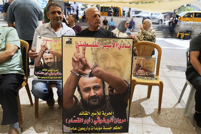 Supporters of popular Palestinian leader Marwan Barghouti carry posters with his pictures while protesting a video that was posted by an Israeli minister.