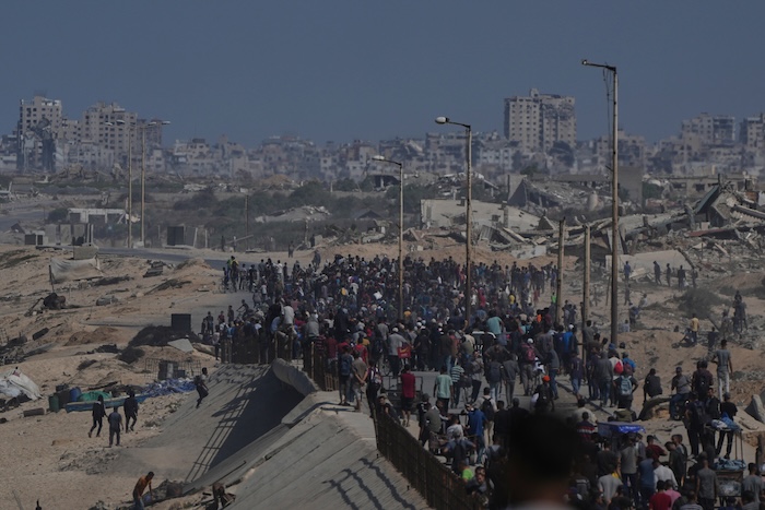 Displaced Palestinians walk along the coastal road near Wadi Gaza in the central Gaza Strip, moving toward northern Gaza, Friday, Oct. 10, 2025, after Israel and Hamas have agreed to a pause in their war and the release of the remaining hostages. (AP Photo/Abdel Kareem Hana)