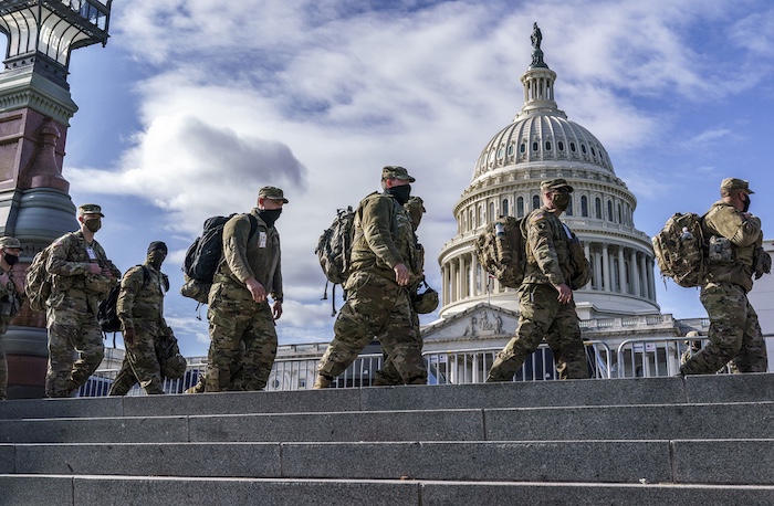National Guard troops walk in front of the Capitol.