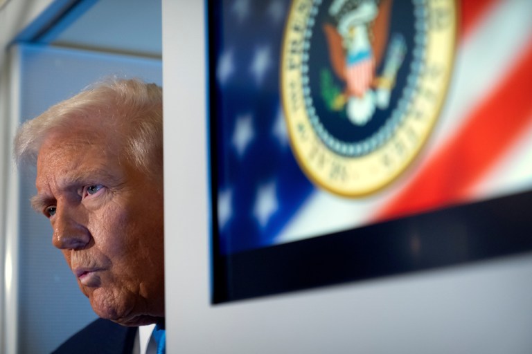 Trump speaks to reporters on Air Force One.