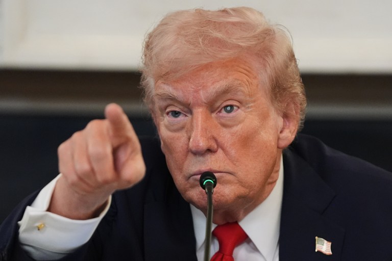 President Donald Trump points during a roundtable meeting.