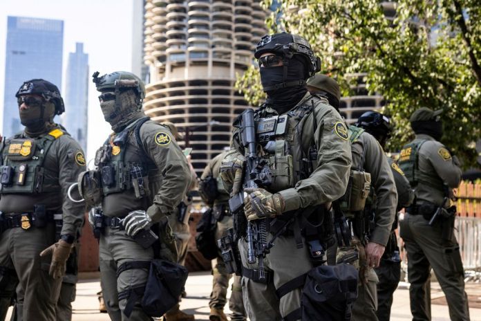 Federal agents from U.S. Immigration and Customs Enforcement and U.S. Customs and Border Protection walk along West Wacker Drive in the Loop, Sunday, Sept. 28, 2025, in Chicago. (Ashlee Rezin/Chicago Sun-Times via AP)