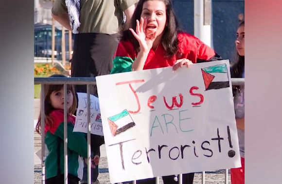 Anti-Israel protestor with a sign that says 