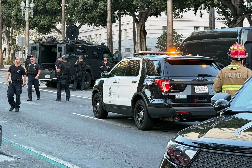 Man with signs referencing Trump barricades himself inside car outside Los Angeles City Hall
