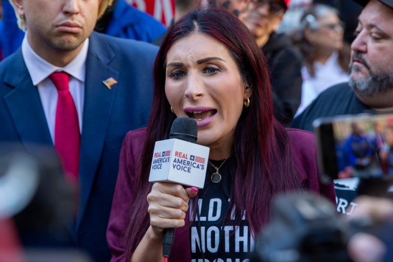 Laura Loomer speaks into a microphone
