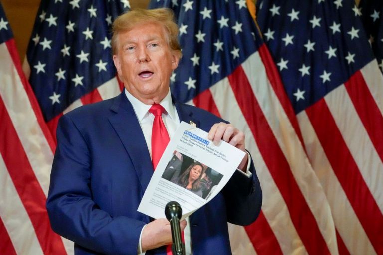 Trump holds up a newspaper article featuring Letitia James.