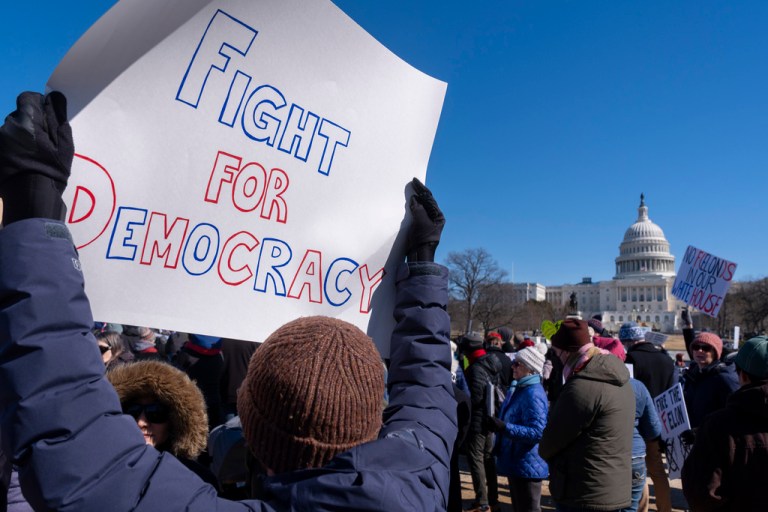 A protester holds a 'Fight for Democracy' sign
