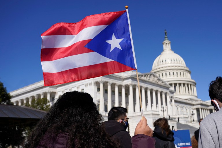A woman waves a Puerto Rico flag on Capitol Hill.