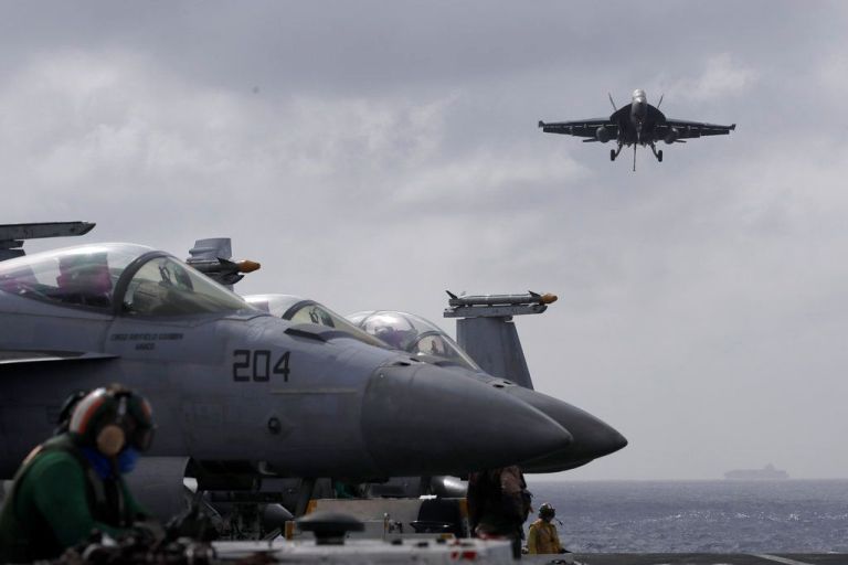 F18 Super Hornet jet lands on carrier.