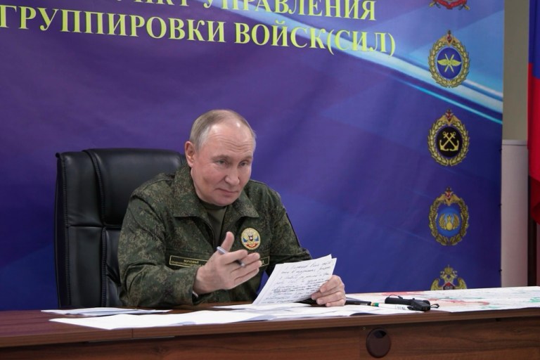 Vladimir Putin speaks in a military uniform