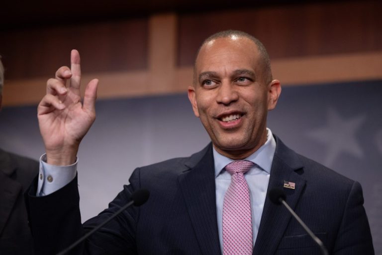 House Minority Leader Hakeem Jeffries (D-NY) raises his hand as he speaks.