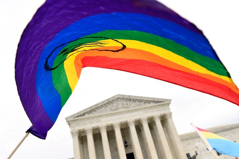 FILE - In this Oct. 8, 2019, file photo, protesters gather outside the Supreme Court in Washington. Legislation that would create new protections for LGBTQ Americans is stalling out in the U.S. Senate. Democrats were hopeful they could pass the Equality Act this year since they control Congress and the White House. (AP Photo/Susan Walsh, File)