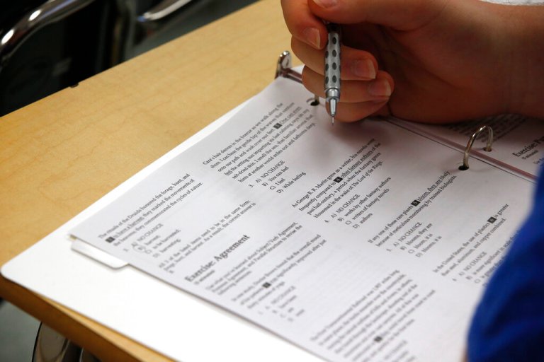 In this photo taken Jan. 17, 2016, a student looks at questions during a college test preparation class at Holton Arms School in Bethesda, Md. The SAT exam will move from paper and pencil to a digital format, administrators announced Tuesday, Jan. 25, 2022, saying the shift will boost its relevancy as more colleges make standardized tests optional for admission.