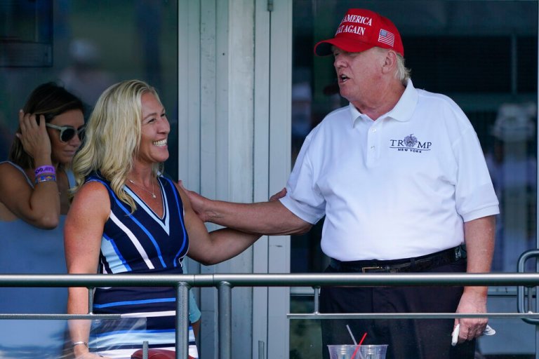 Donald Trump greets U.S. Rep. Marjorie Taylor Greene at the 16th tee during the second round of the Bedminster Invitational LIV Golf tournament in Bedminster, NJ., Saturday, July 30, 2022. (AP Photo/Seth Wenig)