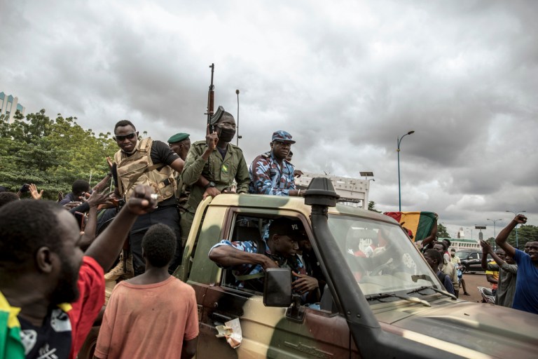 People cheer in celebration as security forces drive through the streets of the capital Bamako, Mali.