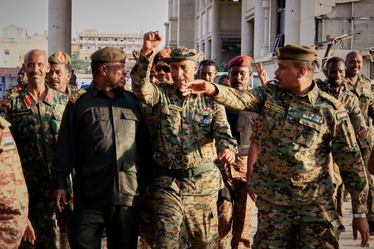 Sudan's military chief Gen. Abdel-Fattah Burhan center, is greeted by troops as he arrives at the Republican Palace, recently recaptured from the Rapid Support Forces paramilitary group, in Khartoum, Sudan, Wednesday, March 26, 2025. (AP Photo)