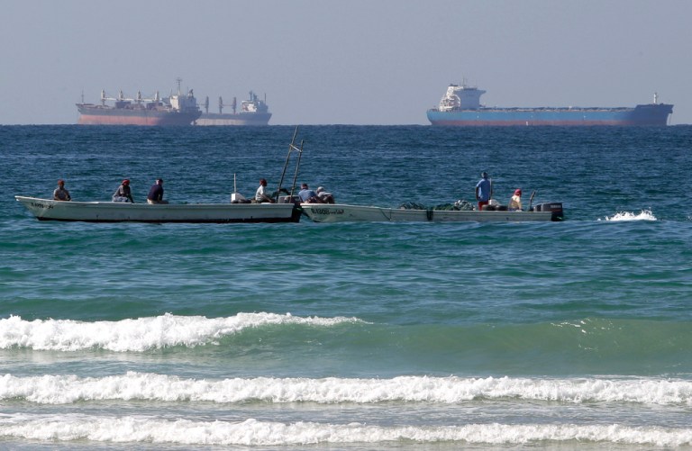In this Jan. 19, 2012 file photo, fishing boats are seen in front of oil tankers south of the Strait of Hormuz.