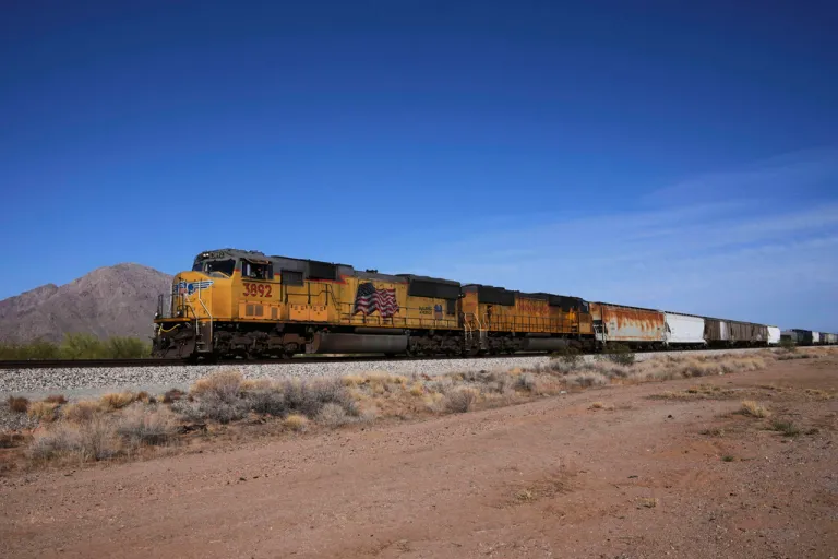 A Union Pacific freight train travels along the tracks.