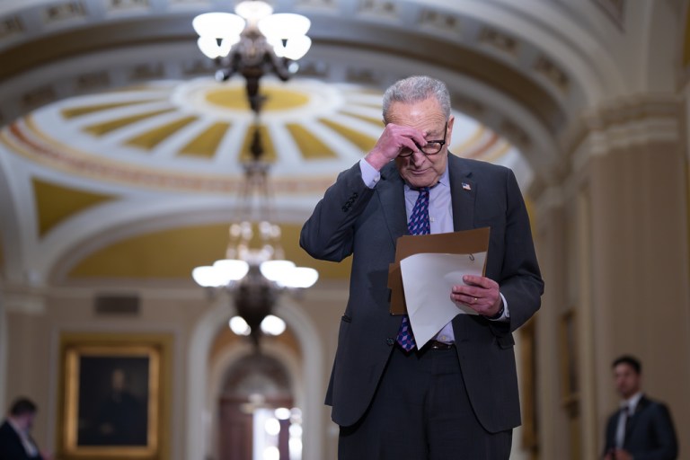 Senate Minority Leader Chuck Schumer, D-N.Y., looks over his notes before speaking with reporters.