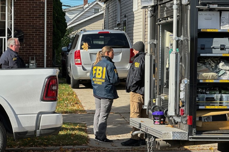 FBI agents gather outside a home in a Dearborn, Mich., neighborhood on Friday, Oct. 31, 2025. (AP Photo/Mike Householder)