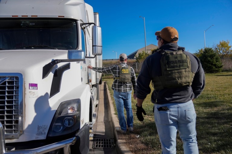 Border Patrol agents conduct an immigration enforcement operation at a truck stop.
