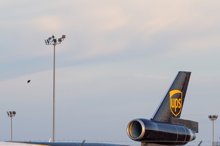The tail engine of a UPS MD-11 plane against the sky.
